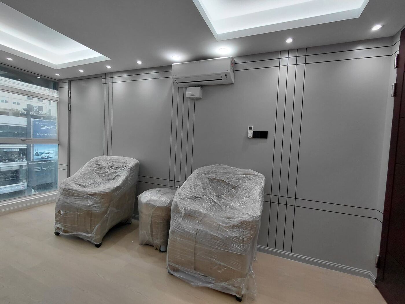 Corporate office lounge with decorative wall panelling, recessed lighting and timber flooring